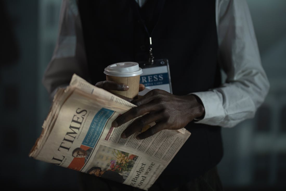 Profesional con periódico y acreditación de prensa